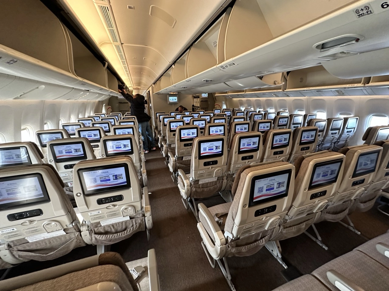Interior view of a China Eastern Airlines aircraft, showcasing economy class seating with personal screens, in preparation for new Shanghai–Auckland–Buenos Aires service.